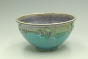 Ceramic bowl with blue and green glaze on a light gray background