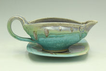 Load image into Gallery viewer, Green ceramic gravy boat with a matching saucer on a light gray background
