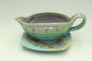Ceramic gravy boat with matching lid on a white background