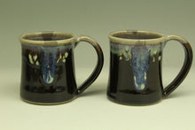 Load image into Gallery viewer, Two black ceramic mugs with a glossy finish on a light gray background