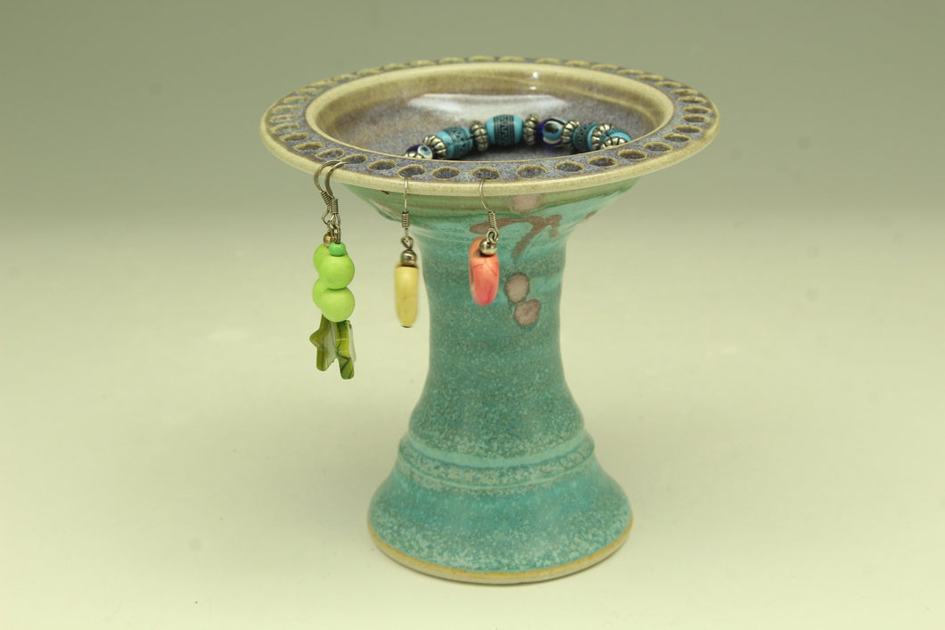 Earring stand with a textured surface on a light green background