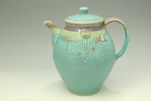Load image into Gallery viewer, Turquoise ceramic teapot with decorative elements on a light gray background